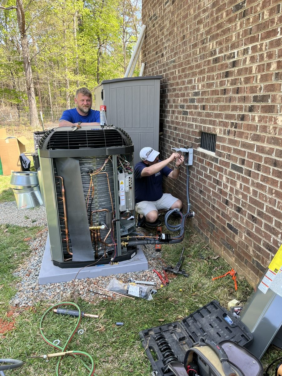 Penguin Air and Plumbing technicians installing a new AC system at a local home